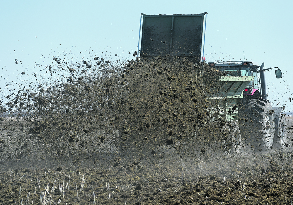 A winter's worth: Neufeld Enterprises loads and spreads solid manure at a dairy farm east of Osler, Sask., April 21.  |  William DeKay photo